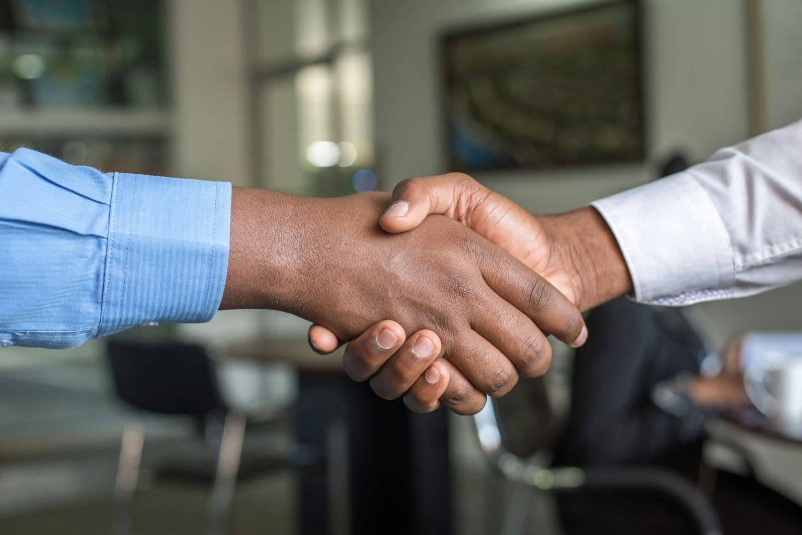[syncsoft-auto][src:unsplash|id:1521791136064-7986c2920216] AI resume screening bias mitigation workflow with recruiter and candidate shaking hands after audit-ready hiring decision