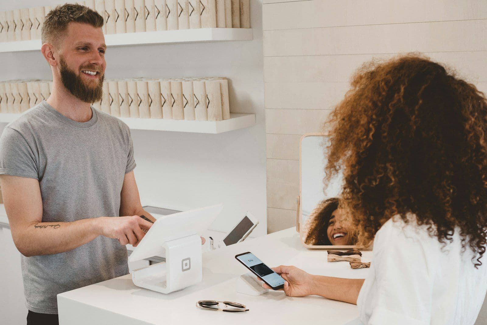 [syncsoft-auto][src:unsplash|id:1556742049-0cfed4f6a45d] Shopper paying by phone at a retail checkout counter, illustrating agentic commerce and AI agent payments at checkout in 2026