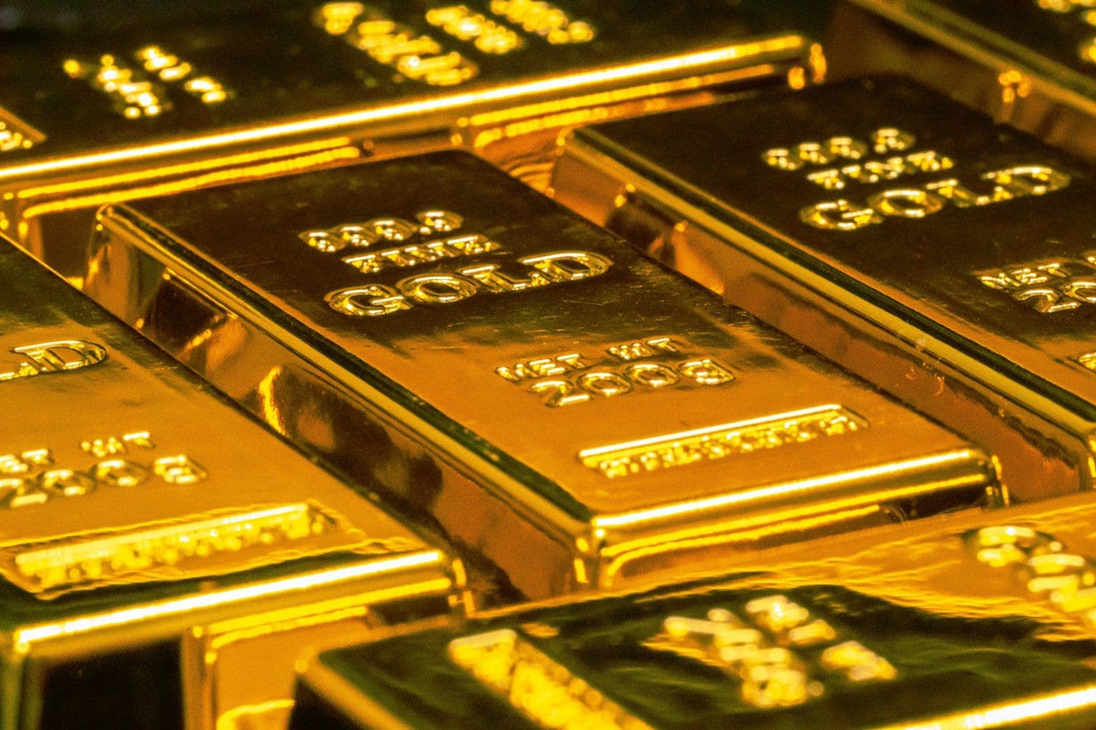 [syncsoft-auto][src:unsplash|id:1610375461246-83df859d849d] Stacked gold bars on a desk — representing the 2026 cross-border compliance BPO market for Chinese fintech going overseas