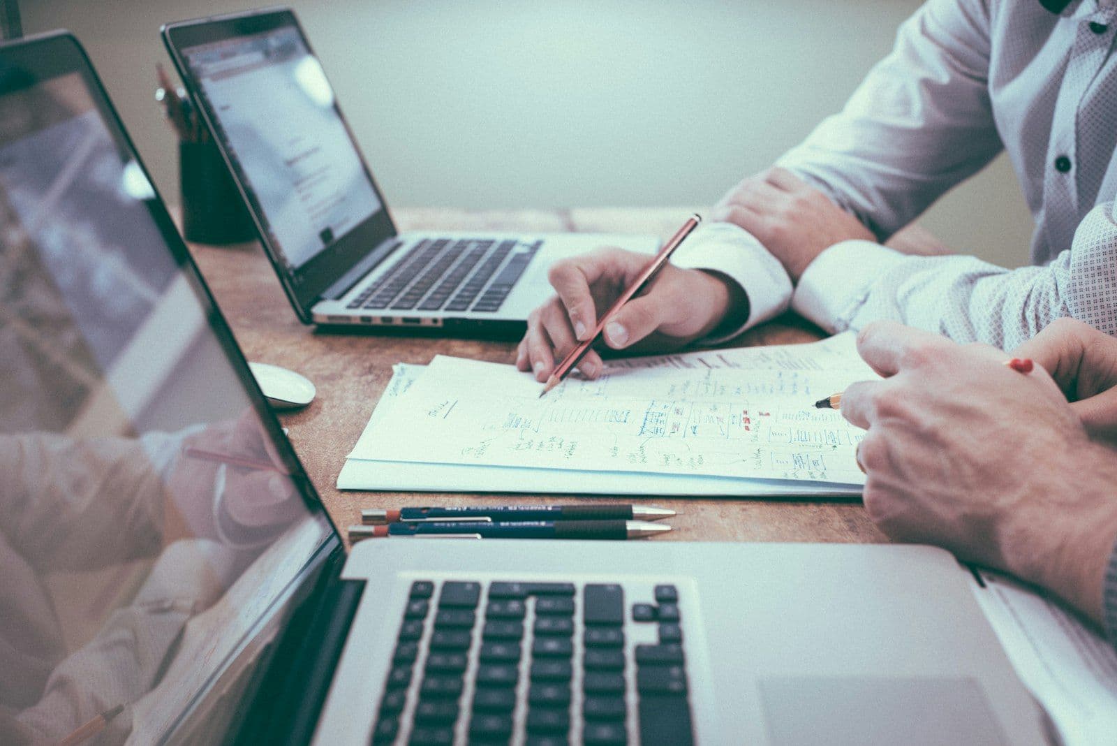 [syncsoft-auto][src:unsplash|id:1454165804606-c3d57bc86b40] Two finance professionals reviewing charts and invoices with laptops, illustrating agentic finance and accounting BPO workflows in 2026