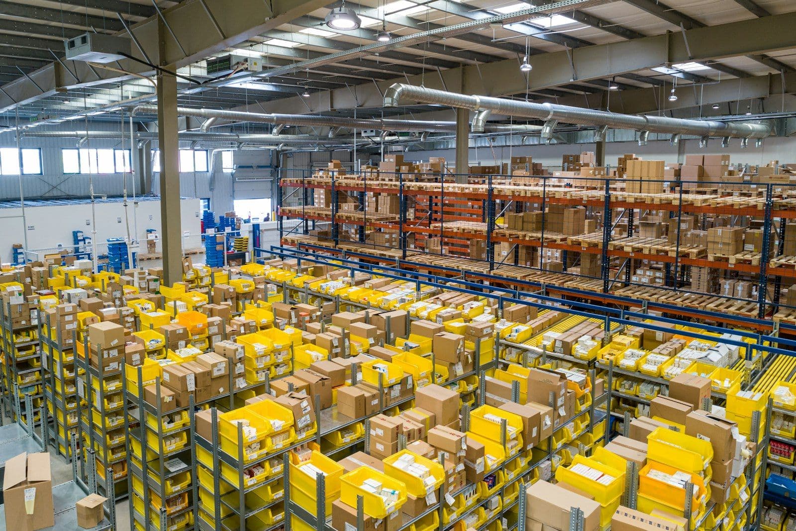 [syncsoft-auto][src:unsplash|id:1586528116311-ad8dd3c8310d] Large cross-border fulfillment warehouse with pallet racks of outbound parcels — representing Chinese 出海 e-commerce logistics